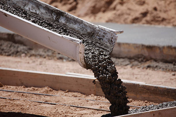 Cement pouring from a mixer truck chute. Some motion blur on the cement.